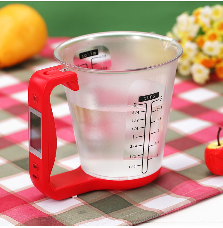 Black handle digital measuring cup scale with clear pitcher showing LCD display readout