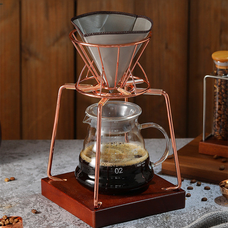 Black metal pour-over coffee stand holding a glass dripper cone over a glass carafe