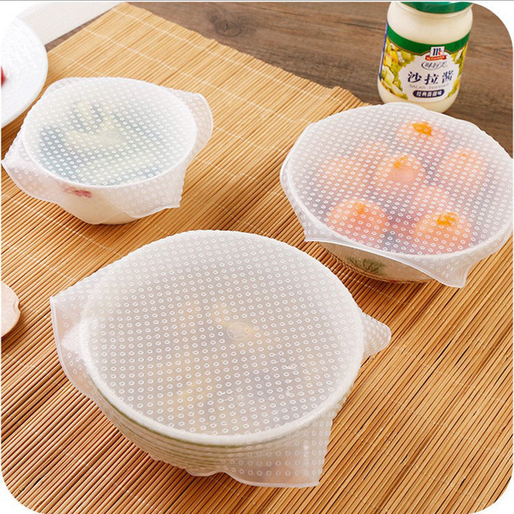 Square transparent silicone food wrap stretched over a ceramic bowl