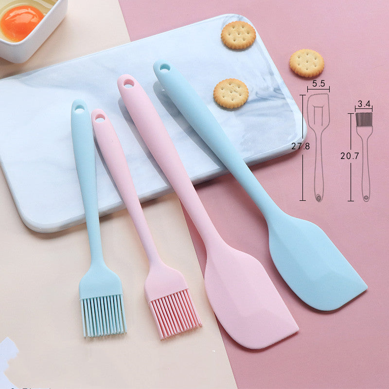 Red seamless silicone baking spatula held over a metal mixing bowl