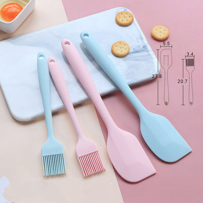 Red seamless silicone baking spatula held over a metal mixing bowl