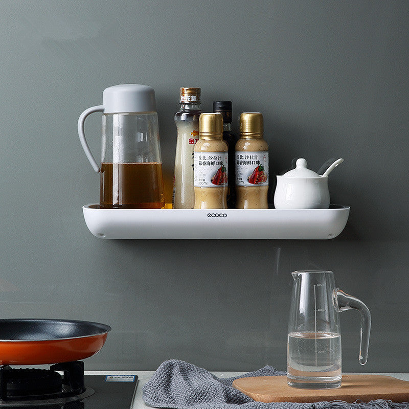 White wall-mounted bathroom storage rack holding shampoo bottles on a tiled shower wall