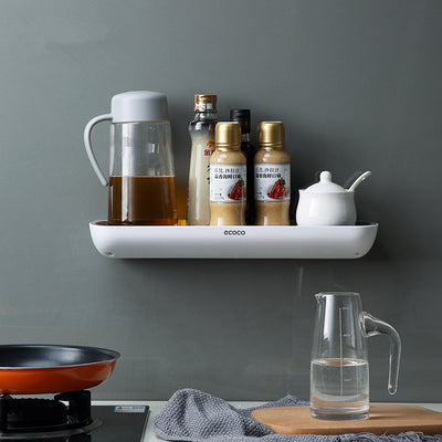 White wall-mounted bathroom storage rack holding shampoo bottles on a tiled shower wall